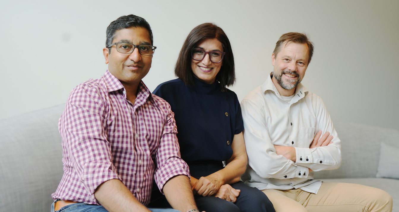 Members of the Pumpfort team sitting together on a sofa, smiling